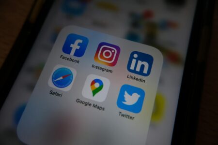 How Bluesky’s Rapid Growth Is Forcing Twitter to Rethink Verification Smartphone displaying social media applications on screen