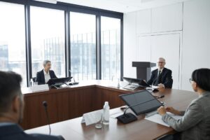 How AI Meeting Transcription Is Replacing Traditional Note-Taking at Law Firms Professional business meeting with lawyers discussing documents around conference table