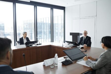How AI Meeting Transcription Is Replacing Traditional Note-Taking at Law Firms Professional business meeting with lawyers discussing documents around conference table