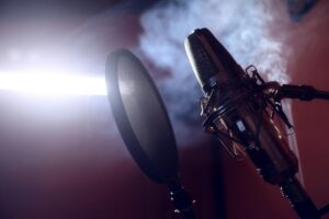 How AI Podcast Editing Is Replacing Traditional Audio Engineers Professional microphone in recording studio with audio equipment in background