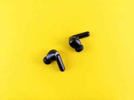 Modern wireless earbuds on a clean white surface showing premium audio technology design