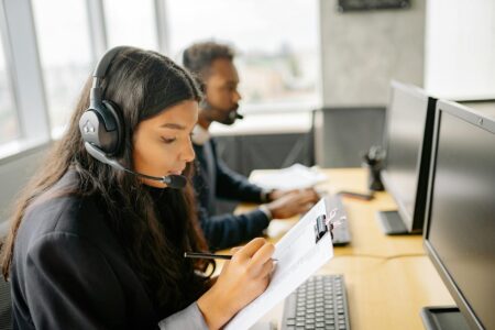 Customer service representative wearing headset at computer workstation