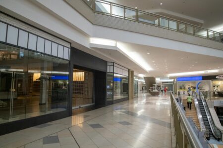 Empty shopping mall interior with vacant storefronts and walkways