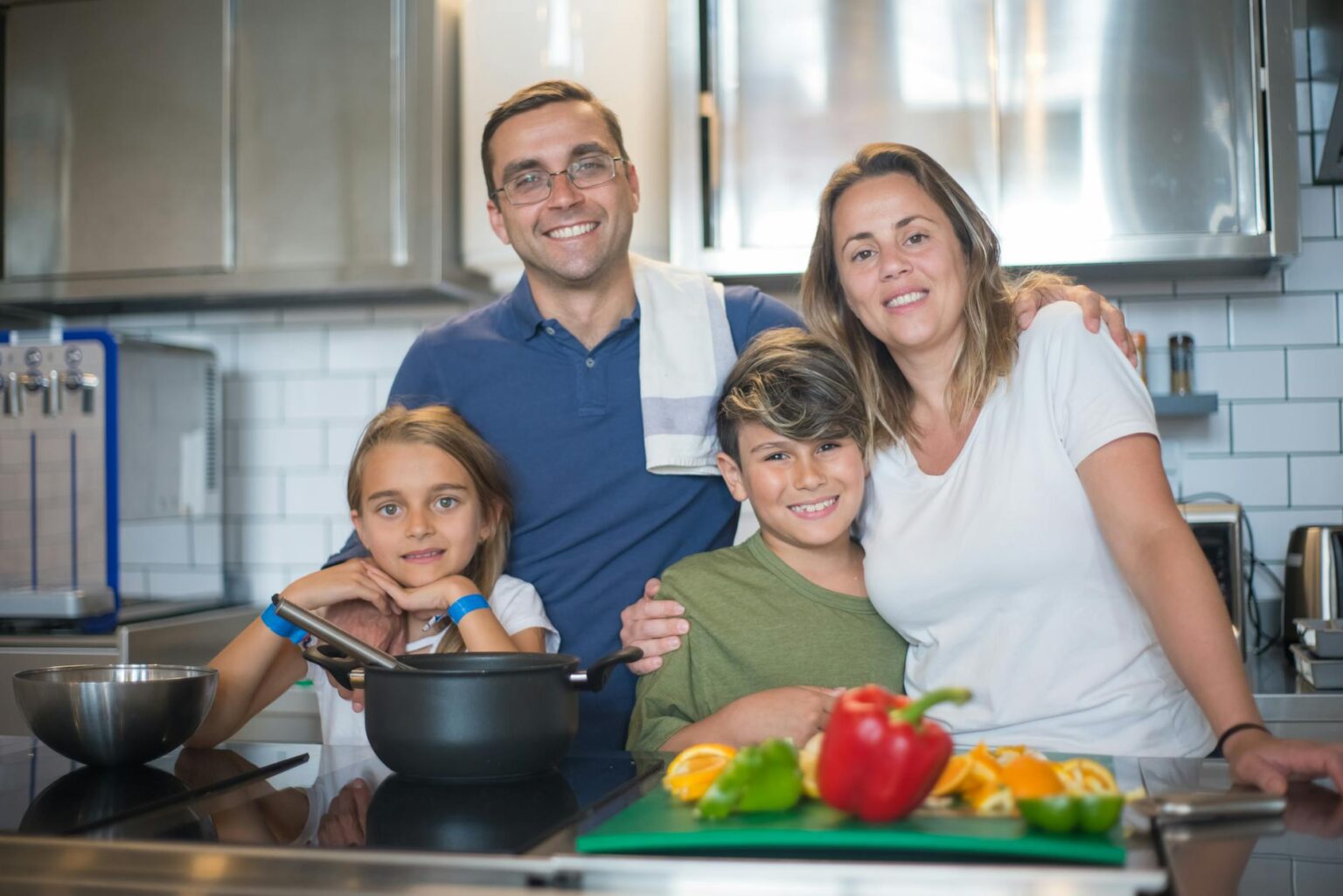 Parent cooking in modern kitchen while child plays nearby, representing multitasking scenarios where voice shopping thrives