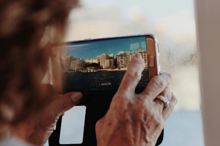 Person holding smartphone recording short-form video content for social media platform