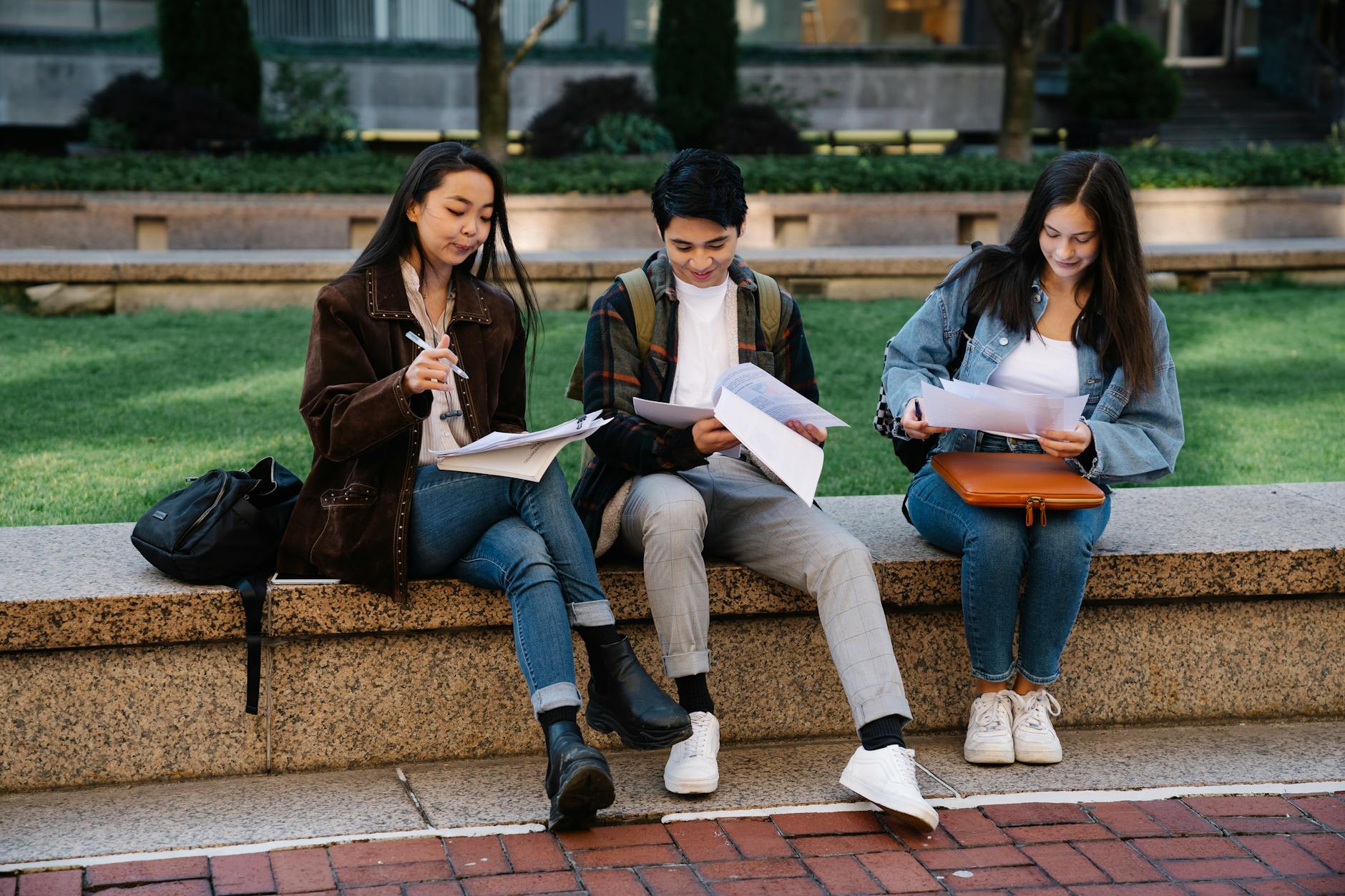 Students walking across a college campus with backpacks and books