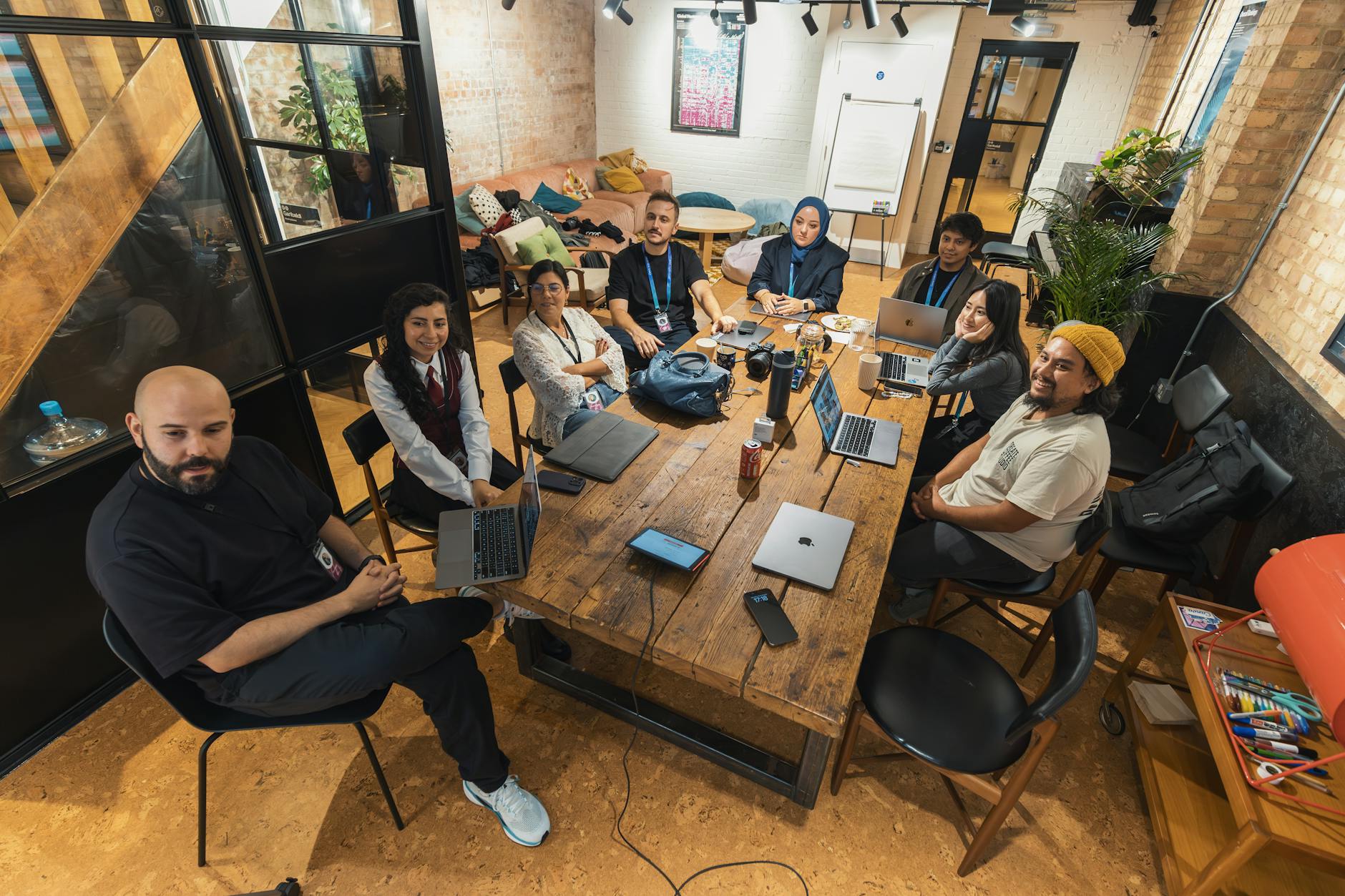 Content creation team collaborating around computer screens in modern office