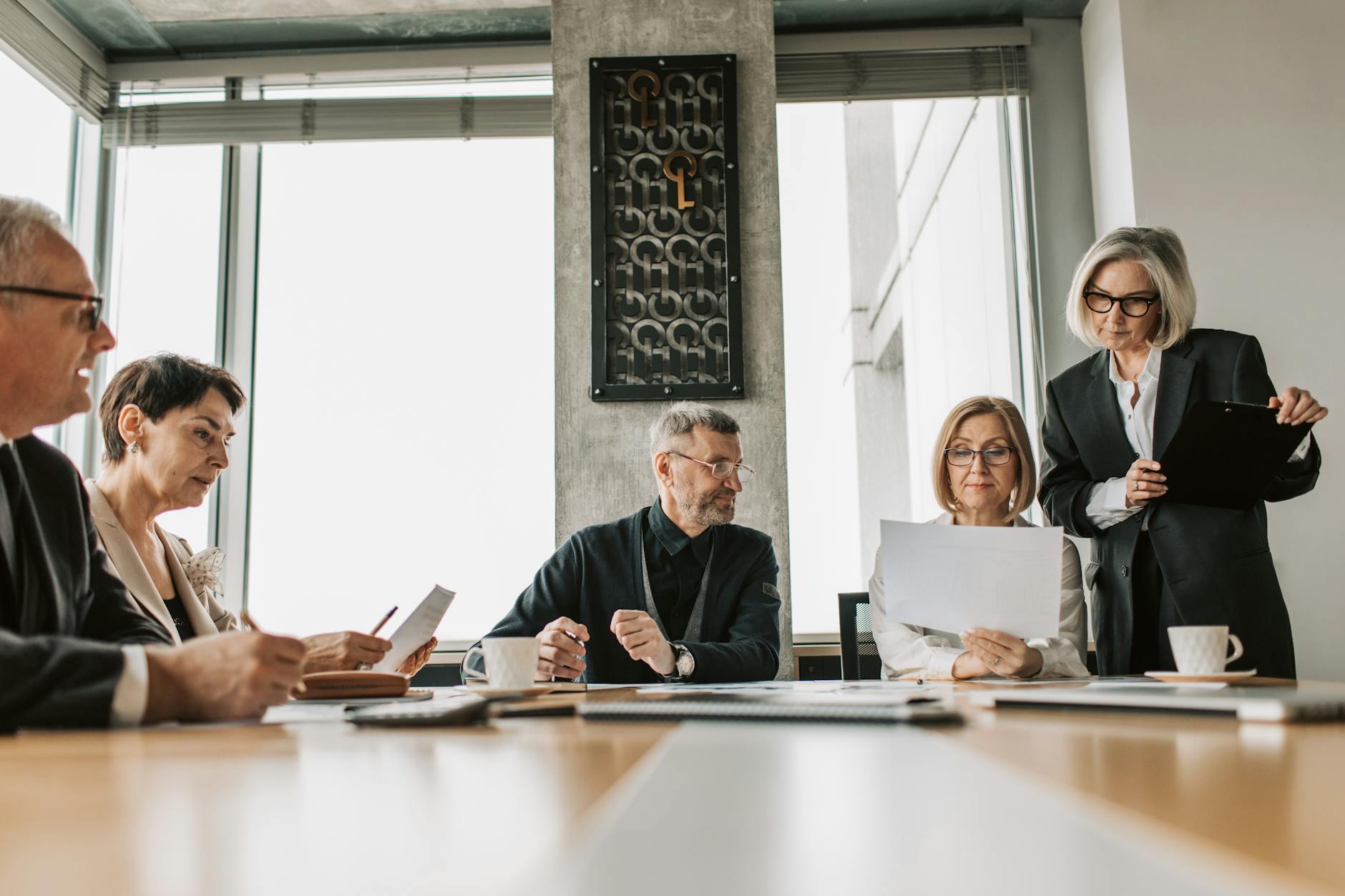 Corporate boardroom with executives discussing hiring strategies around conference table