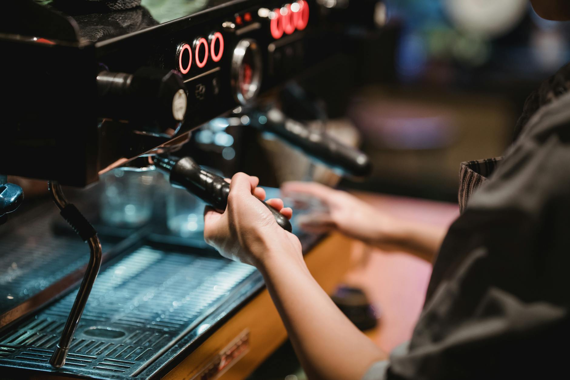 Barista preparing coffee drinks behind espresso machine