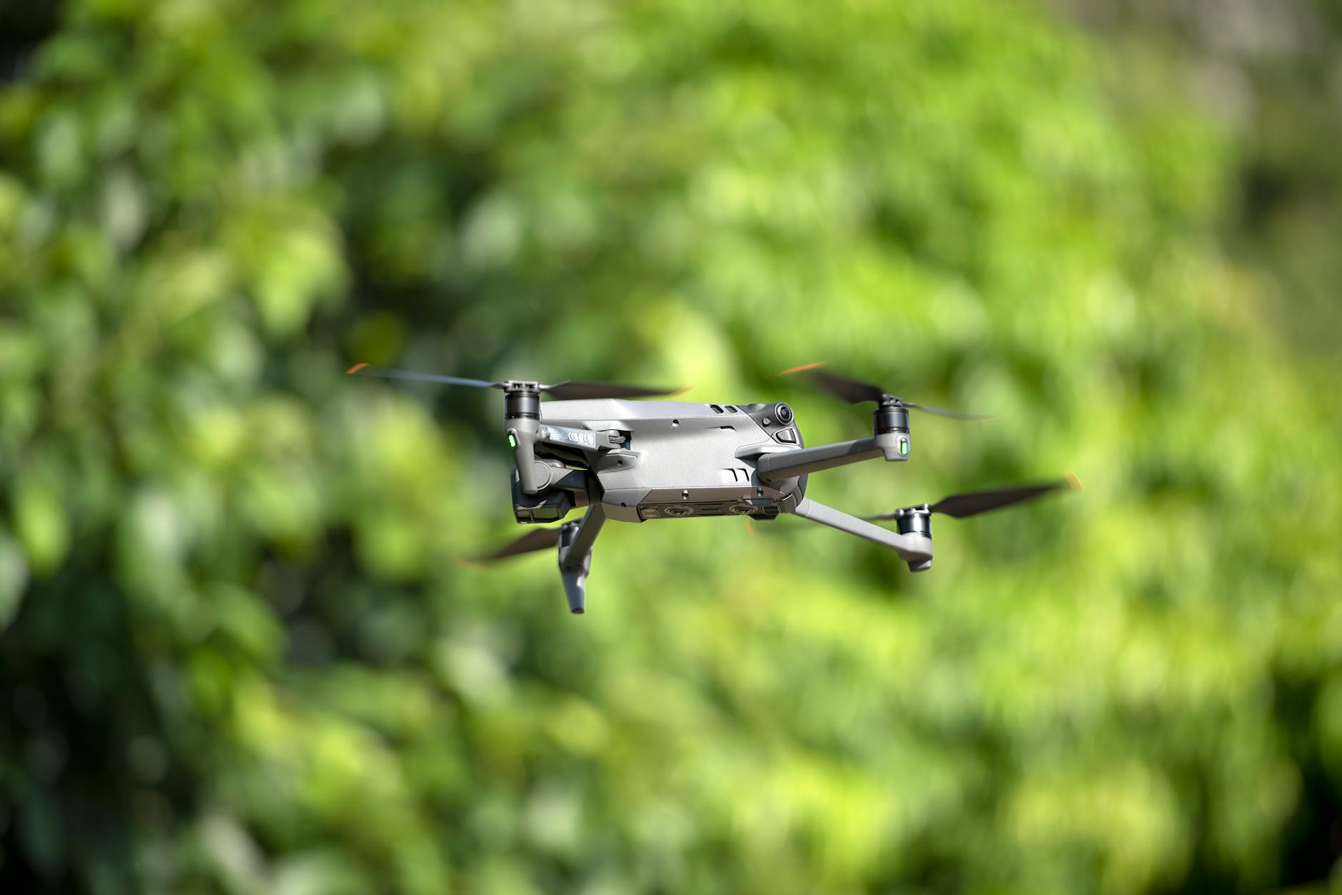 Modern wireless headphones on desk with digital devices in background