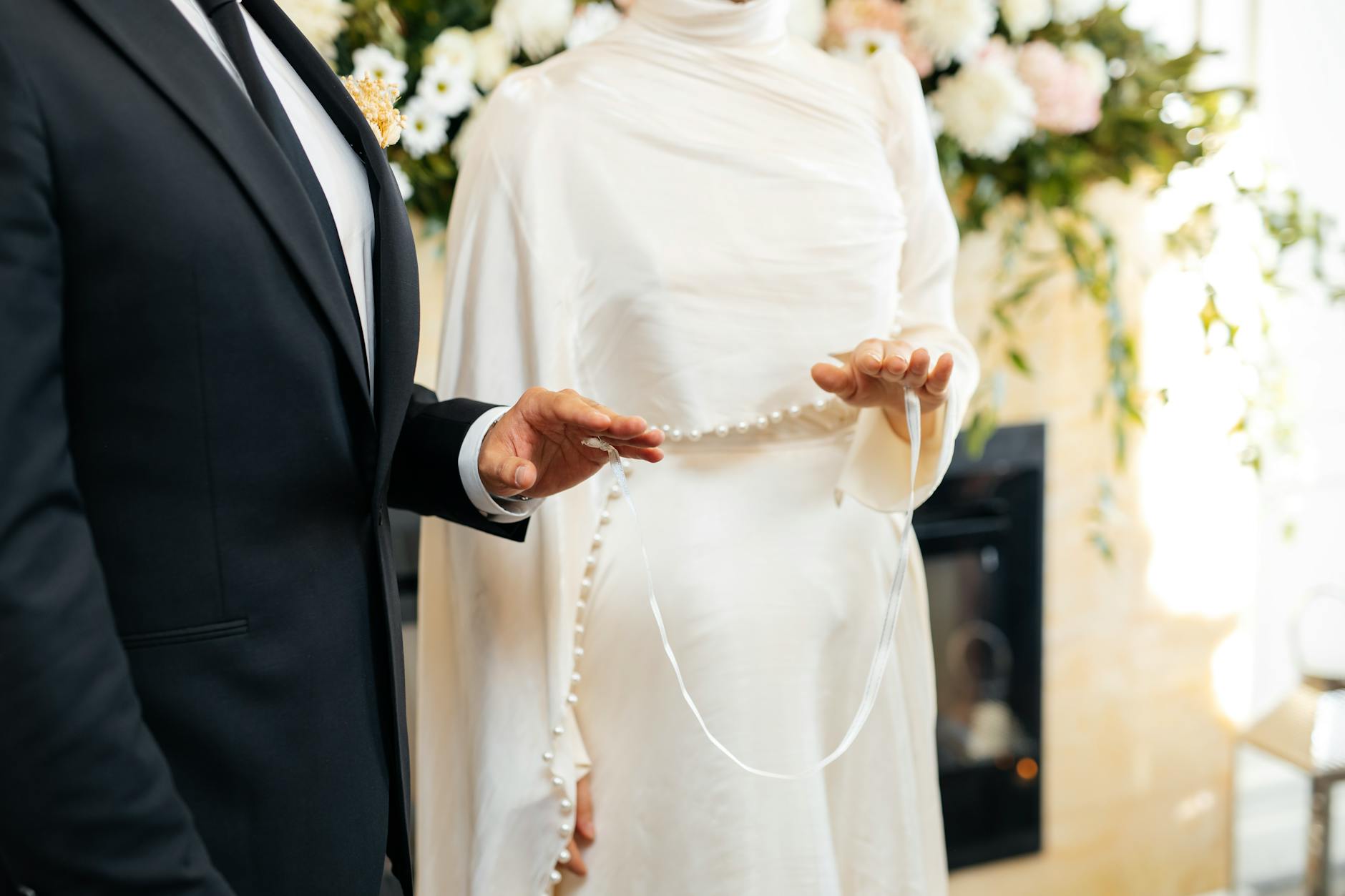 Elegant outdoor wedding ceremony setup with white chairs and floral decorations