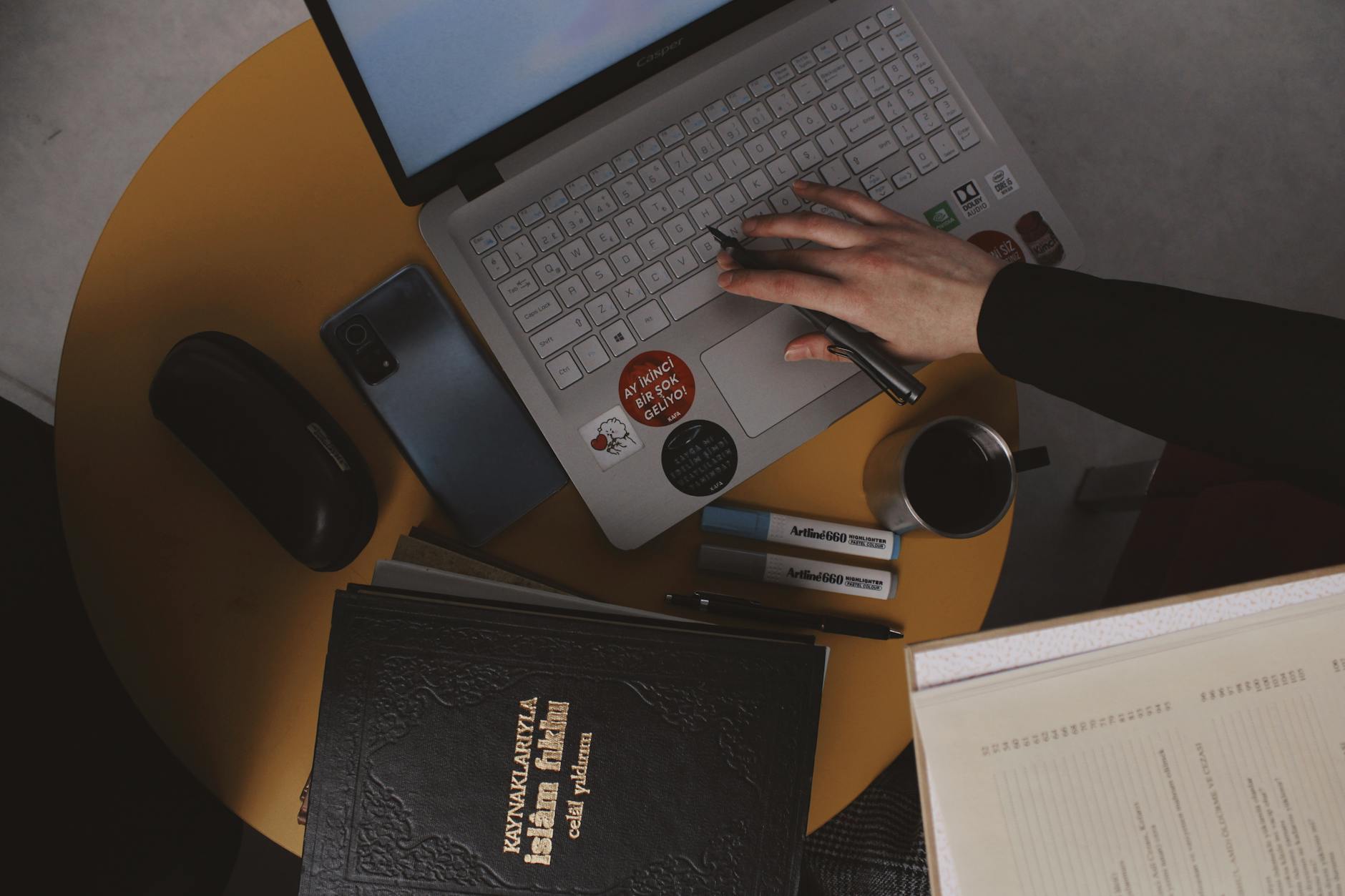 Professional workspace with laptop displaying writing interface and notebooks
