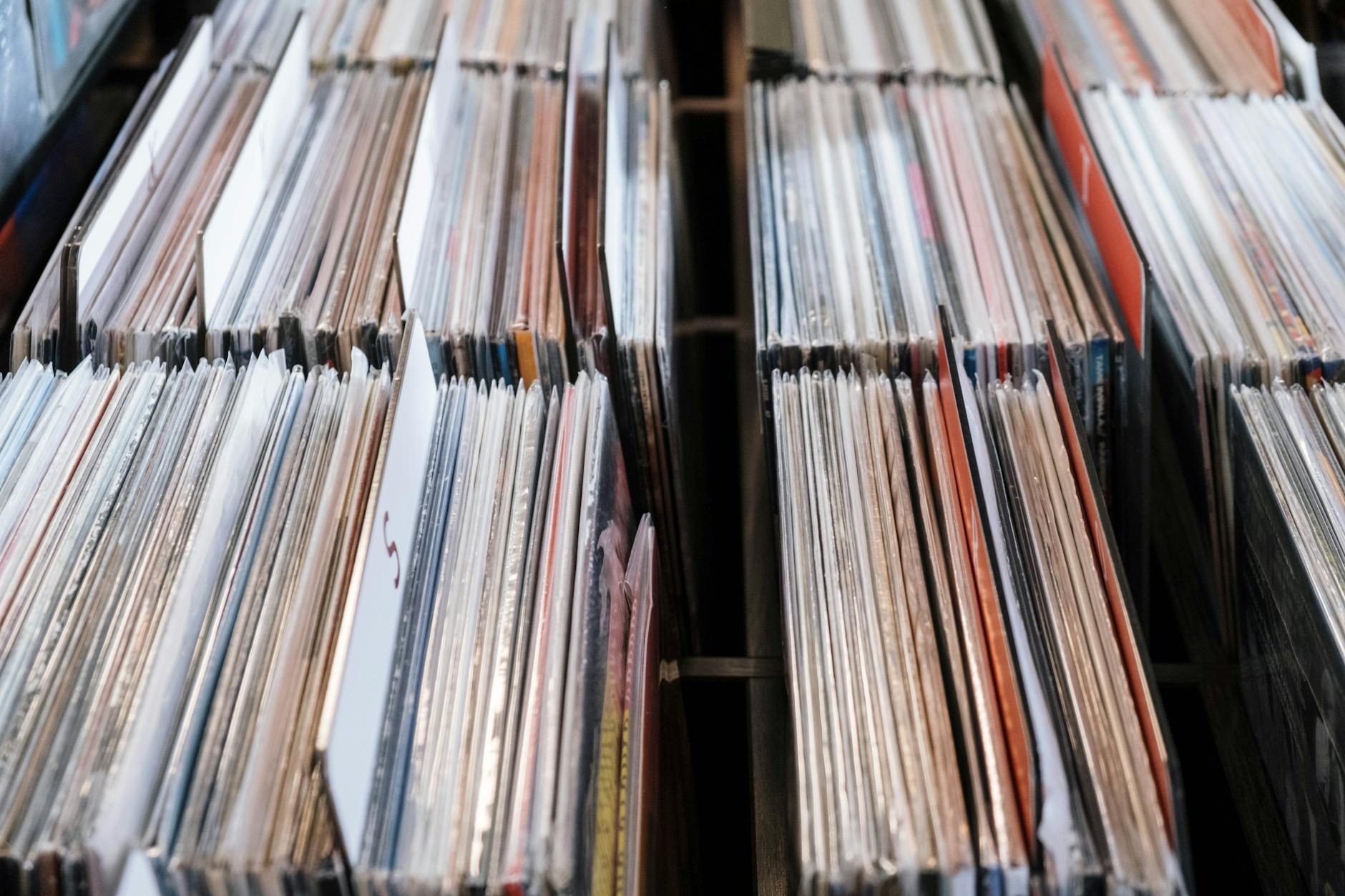 Collection of vinyl records stacked on wooden surface