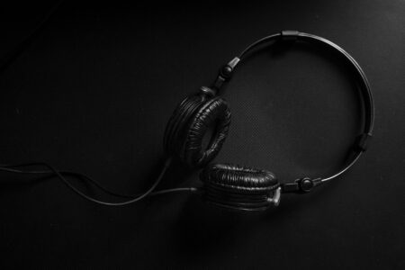 Smartphone with headphones in dark setting showing audio-only listening