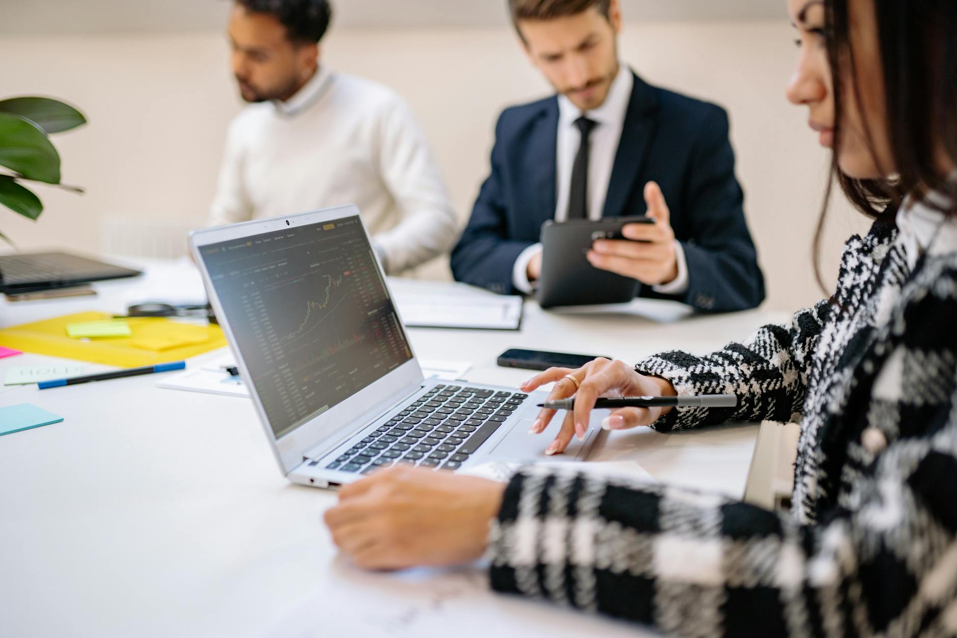 Business professionals reviewing data on laptops during an enterprise meeting