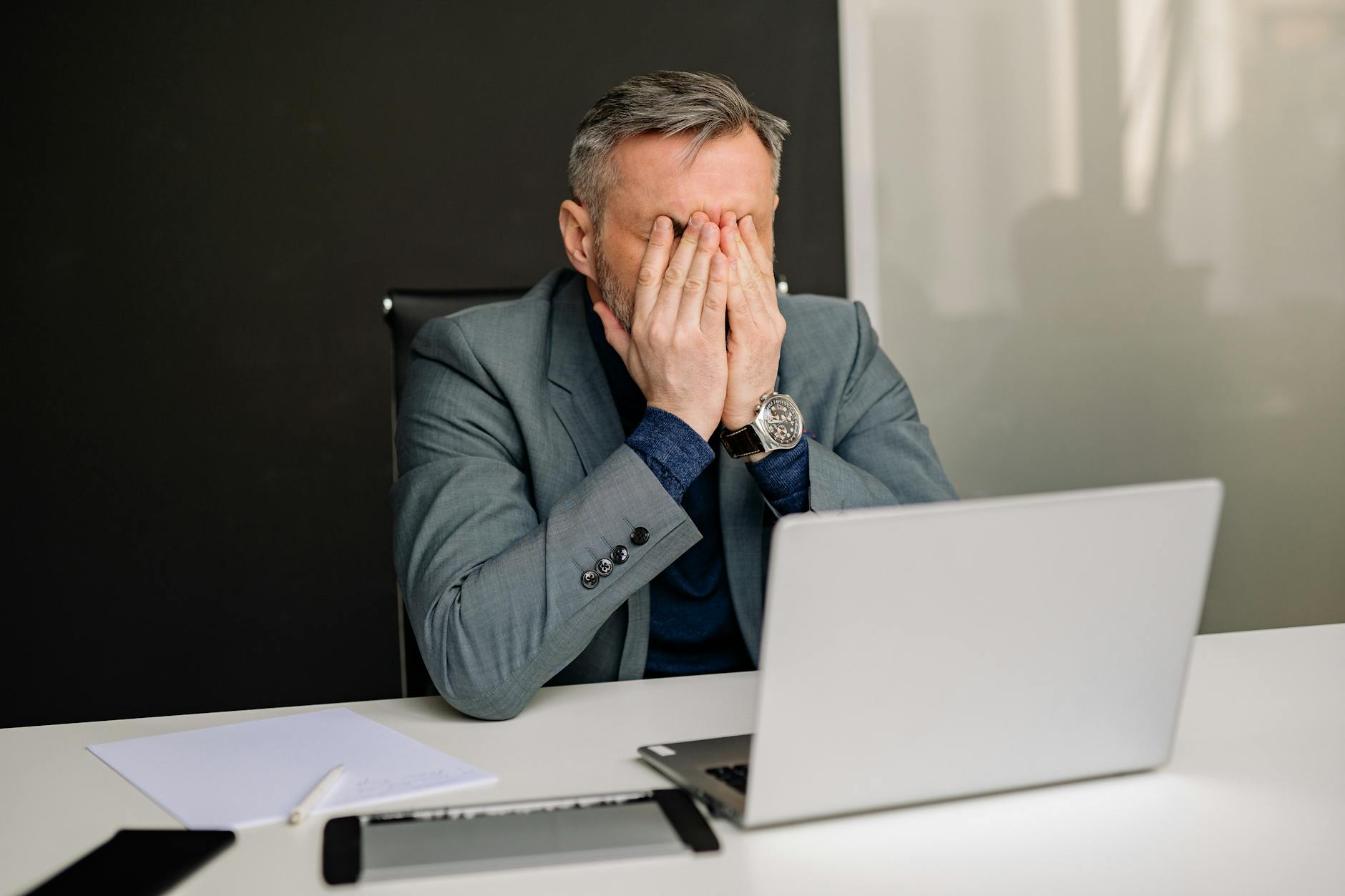 Frustrated businessman looking at computer screen in modern office setting