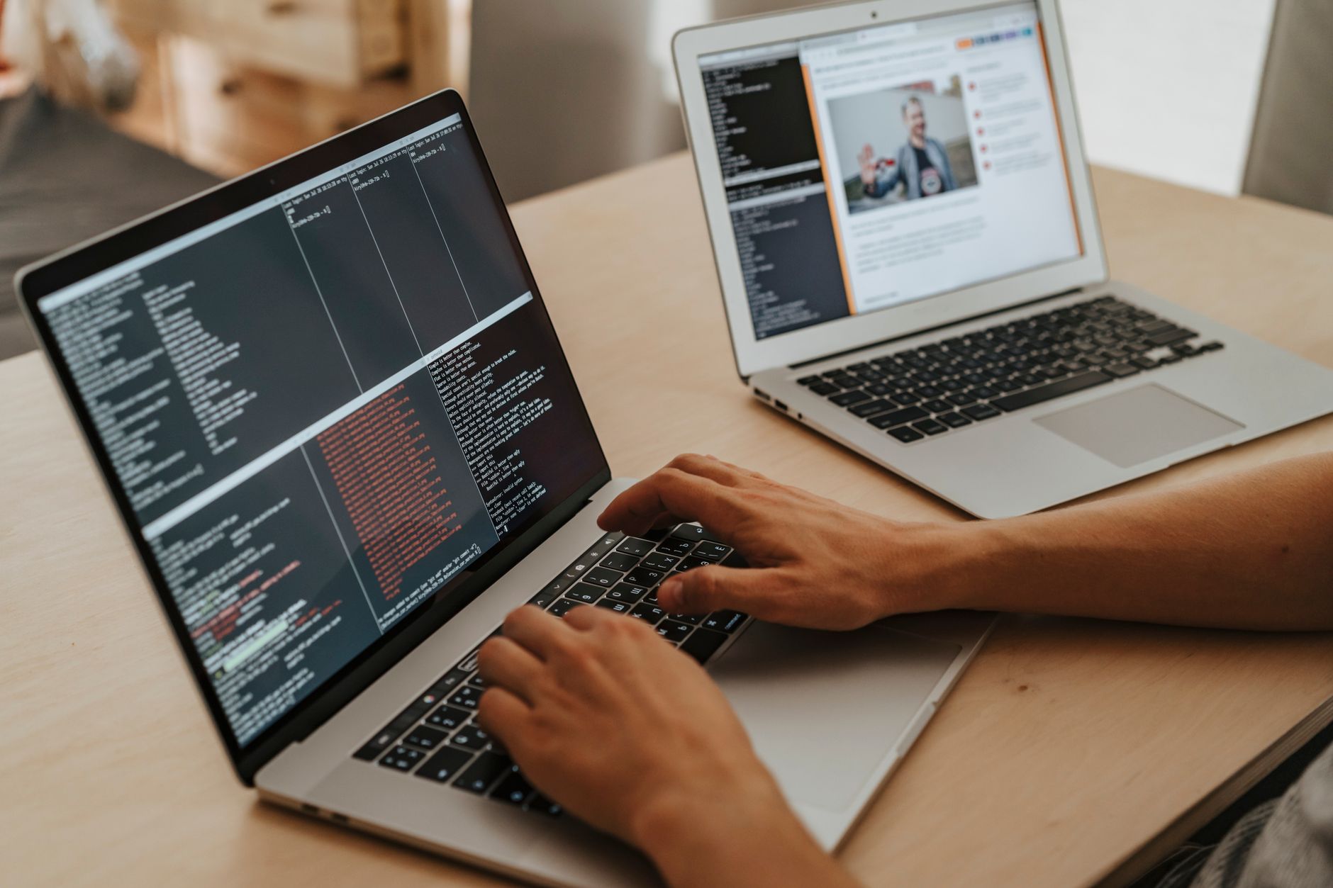 A developer writing code on a laptop in a modern office environment