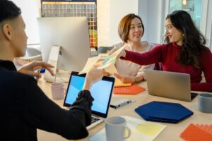 Designers and developers collaborating around a screen during a product handoff meeting