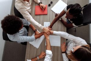 Team members collaborating on documents at a shared office workspace