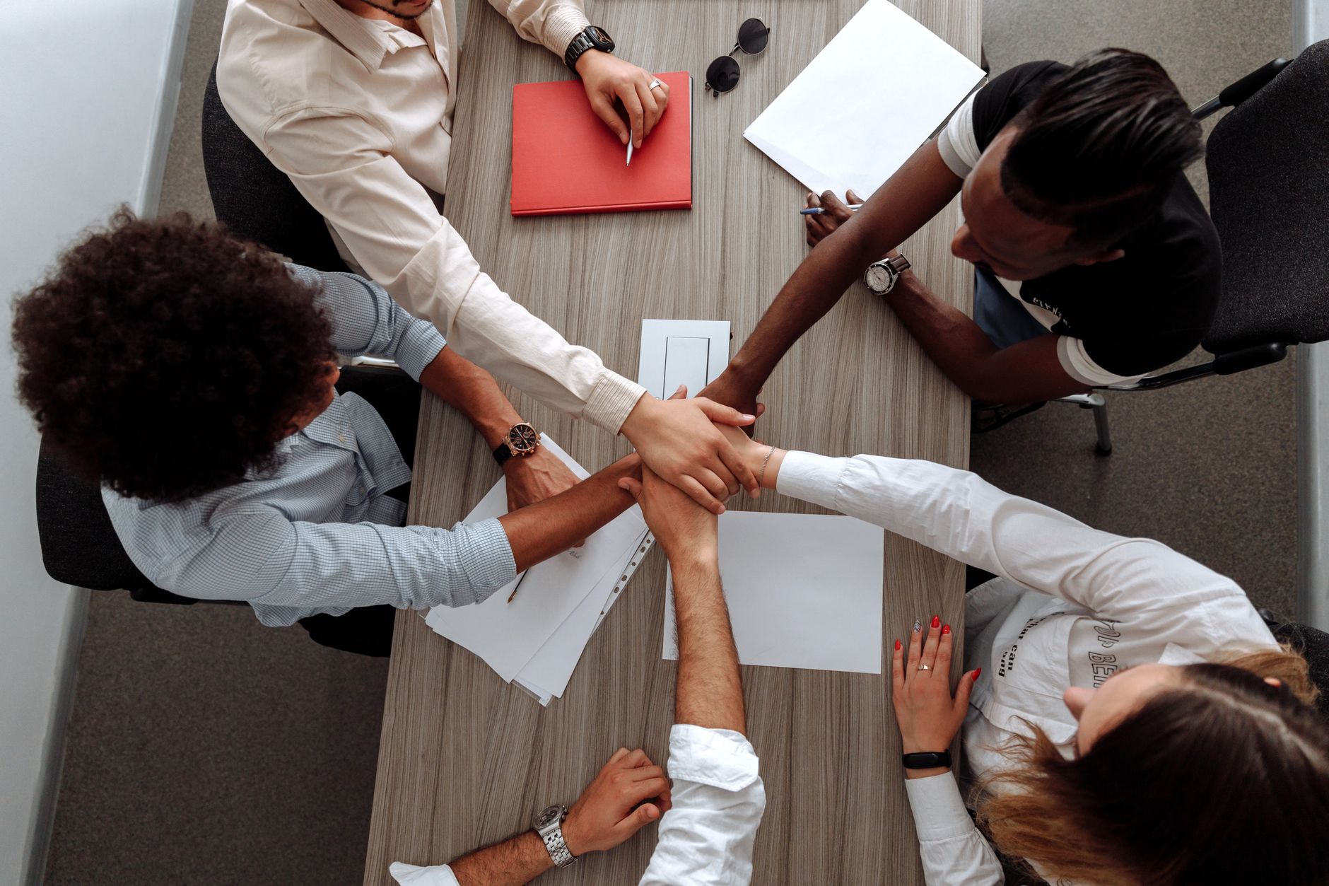 Team members collaborating on documents at a shared office workspace