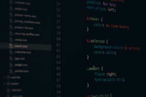 Developer working on code at a computer screen displaying a web application interface