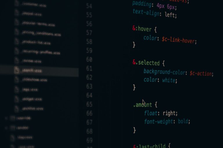 Developer working on code at a computer screen displaying a web application interface