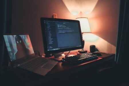 Developer working at a modern coding workstation with multiple screens