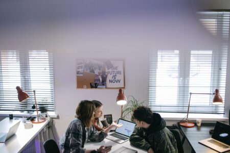 Enterprise team collaborating around a laptop in a modern office setting