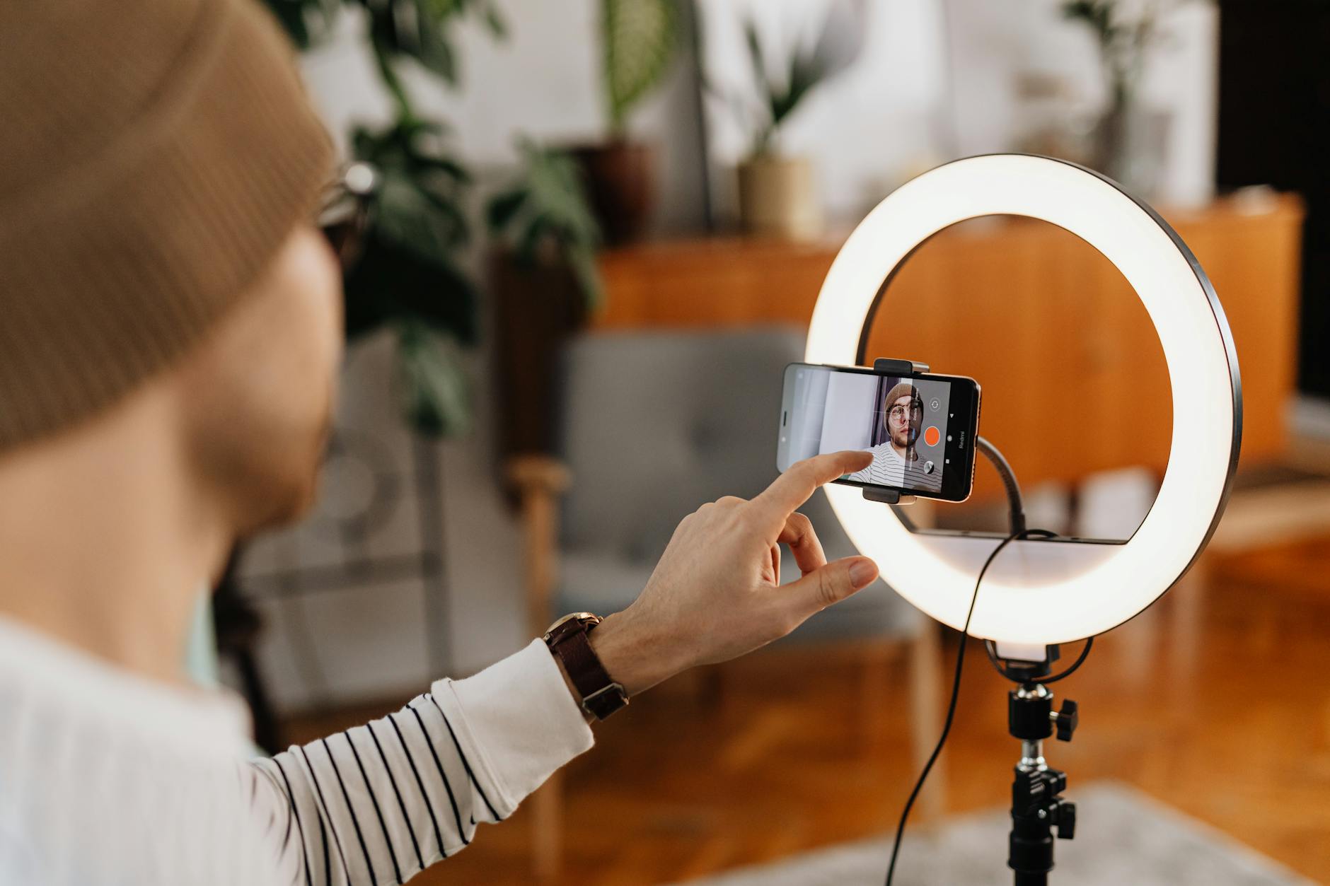 A content creator recording and editing video in a small home studio setup