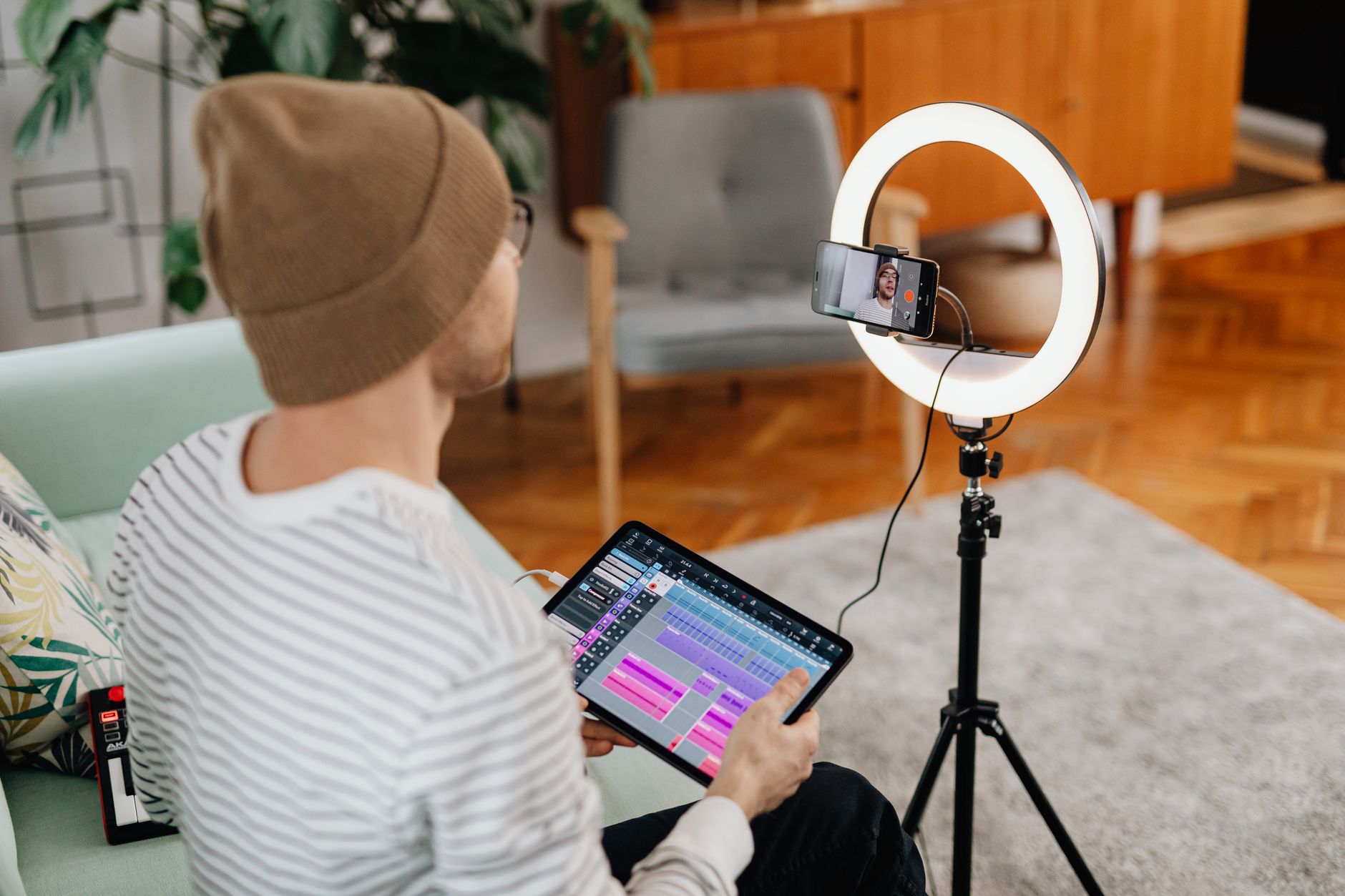 A content creator working at a desk with monitors and recording equipment