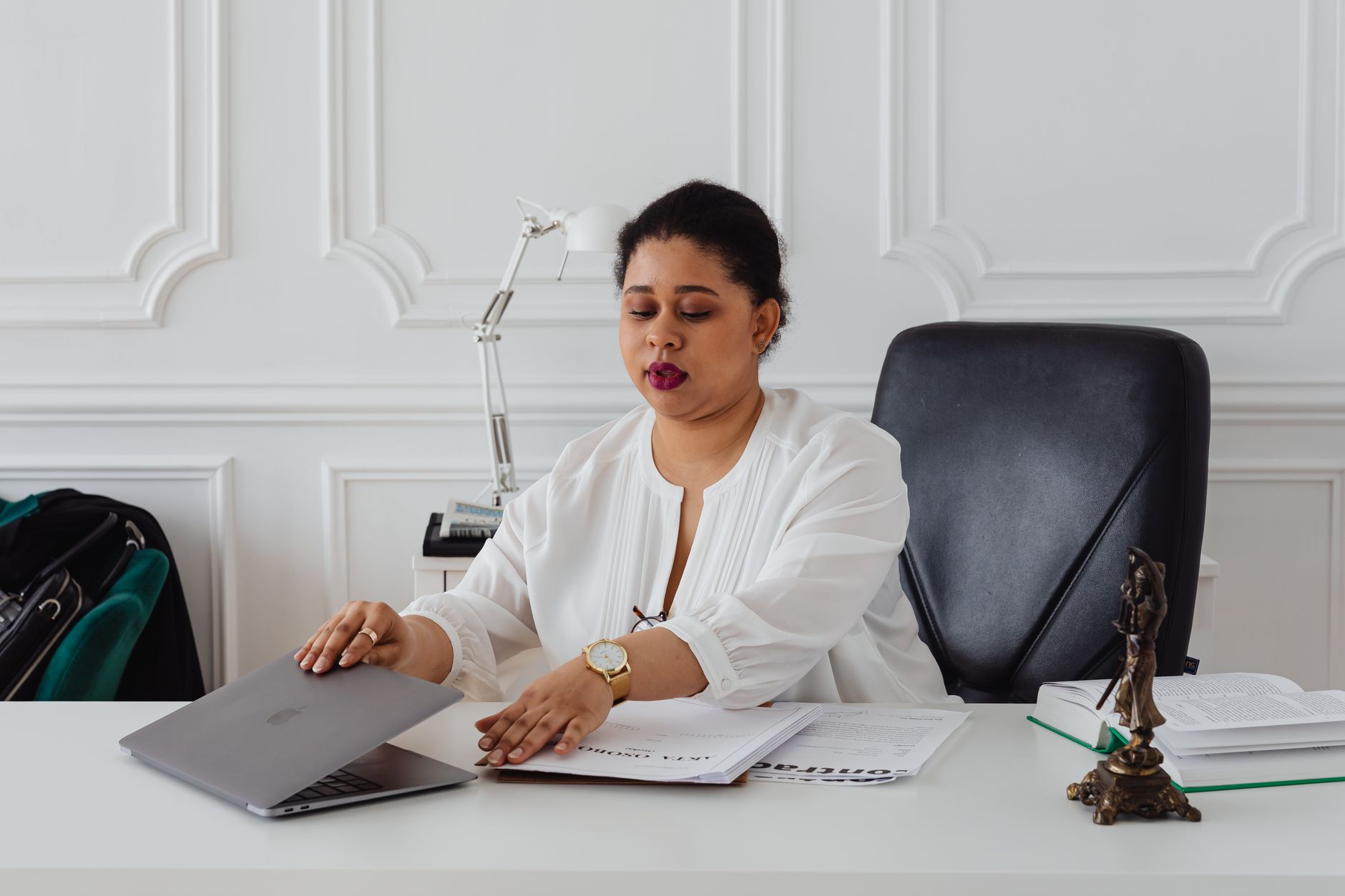 Attorney reviewing documents on a laptop in a modern office environment