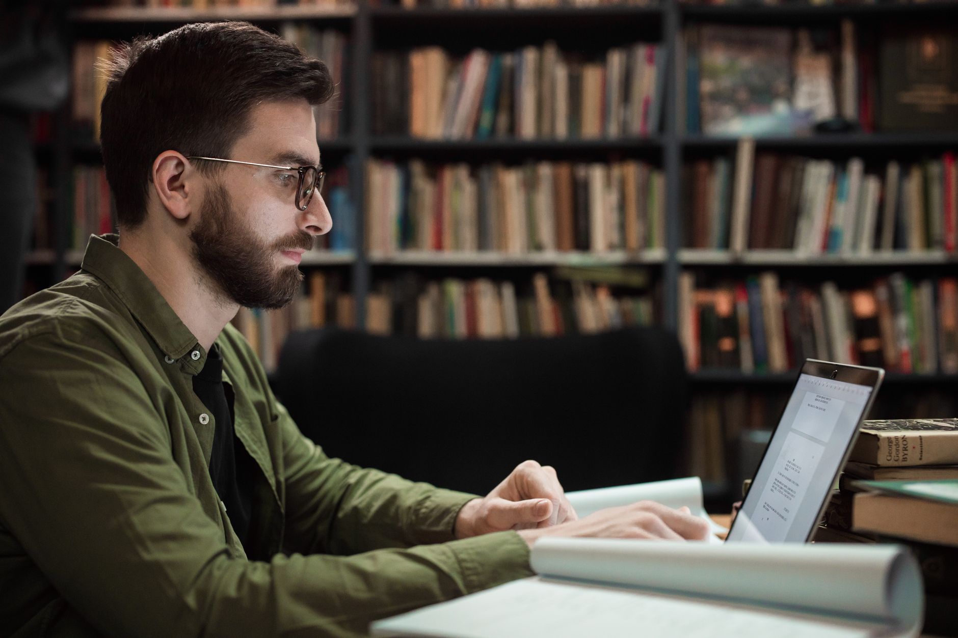 Professional working with knowledge management data on dual monitors at a desk