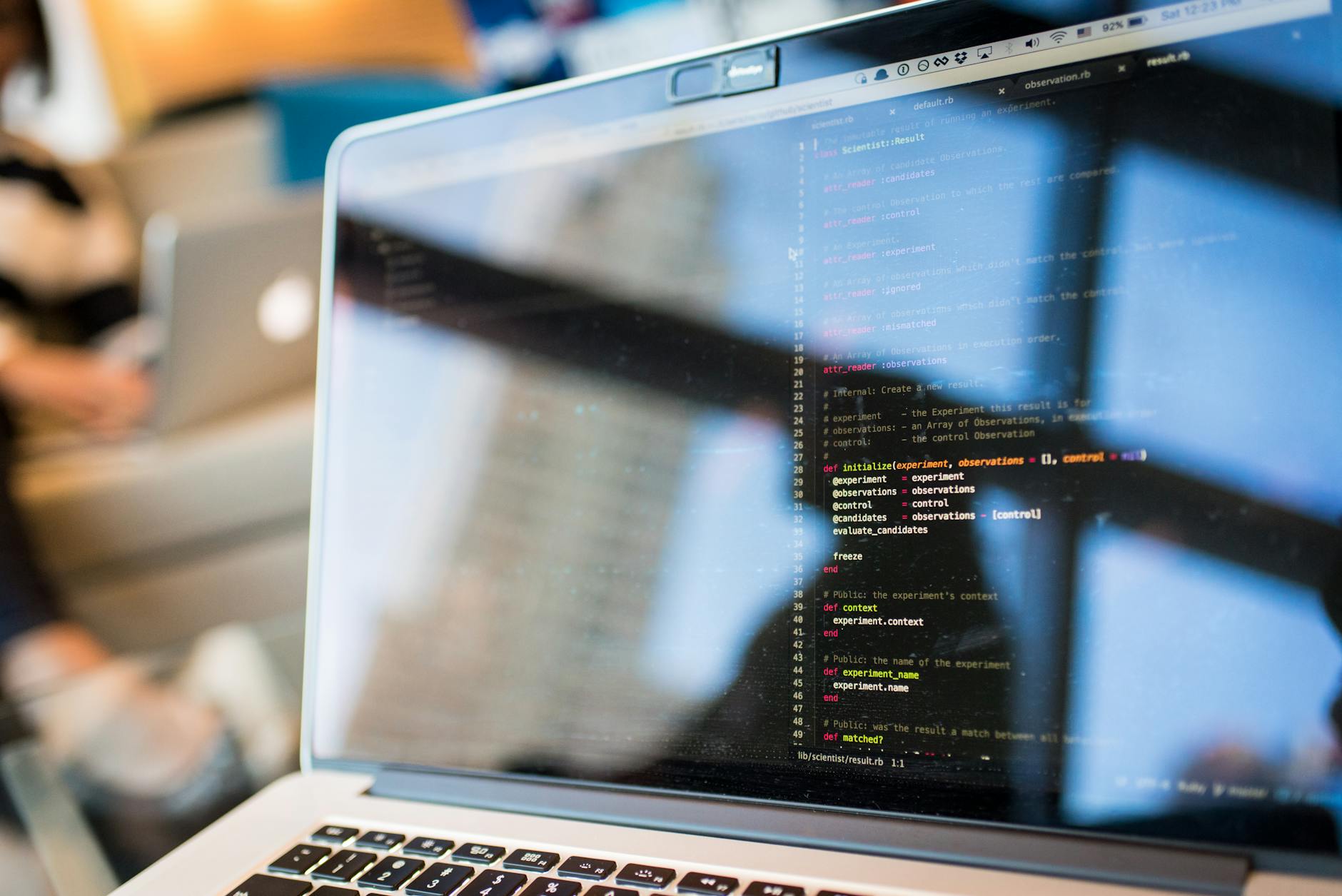 Software developer typing on a laptop with code visible on screen