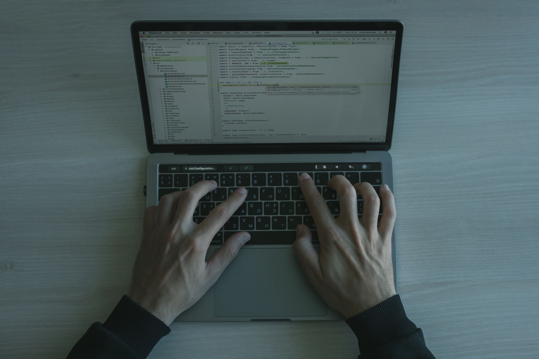 A software engineer reviewing code on a laptop in an office setting