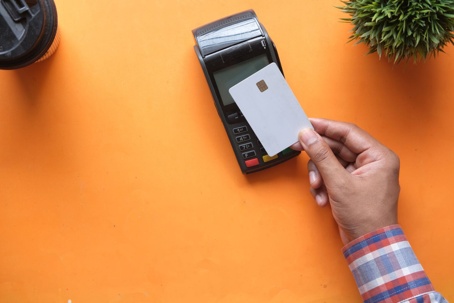 Cardless’s Co-Branded Credit Cards Are Squeezing Marqeta’s Bank Partnerships Person holding a credit card near a payment terminal
