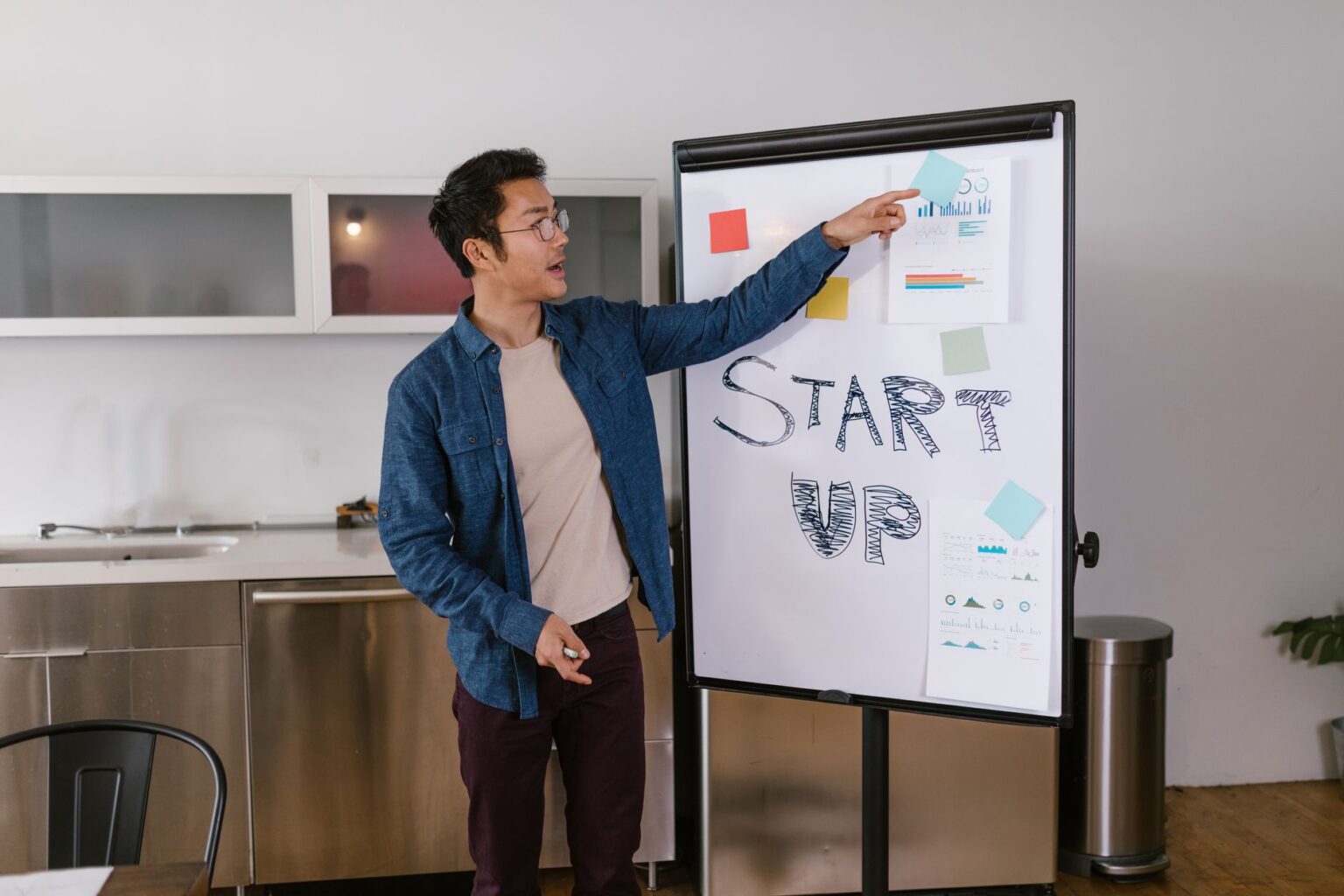 Two founders reviewing a pitch deck presentation on a laptop in a modern office setting