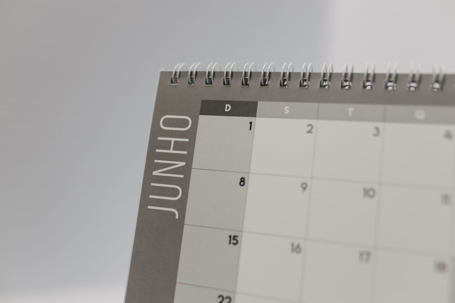 A clean desk workspace with a calendar and laptop open for daily planning