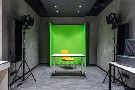 A modern video production studio with screens displaying digital editing software