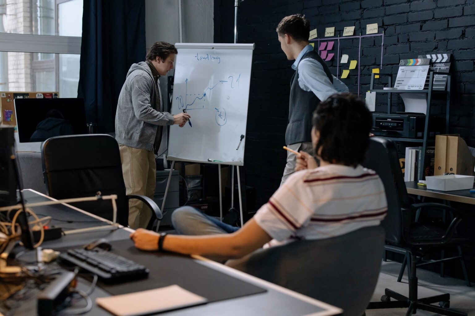 Small startup team working together on laptops in a modern office space