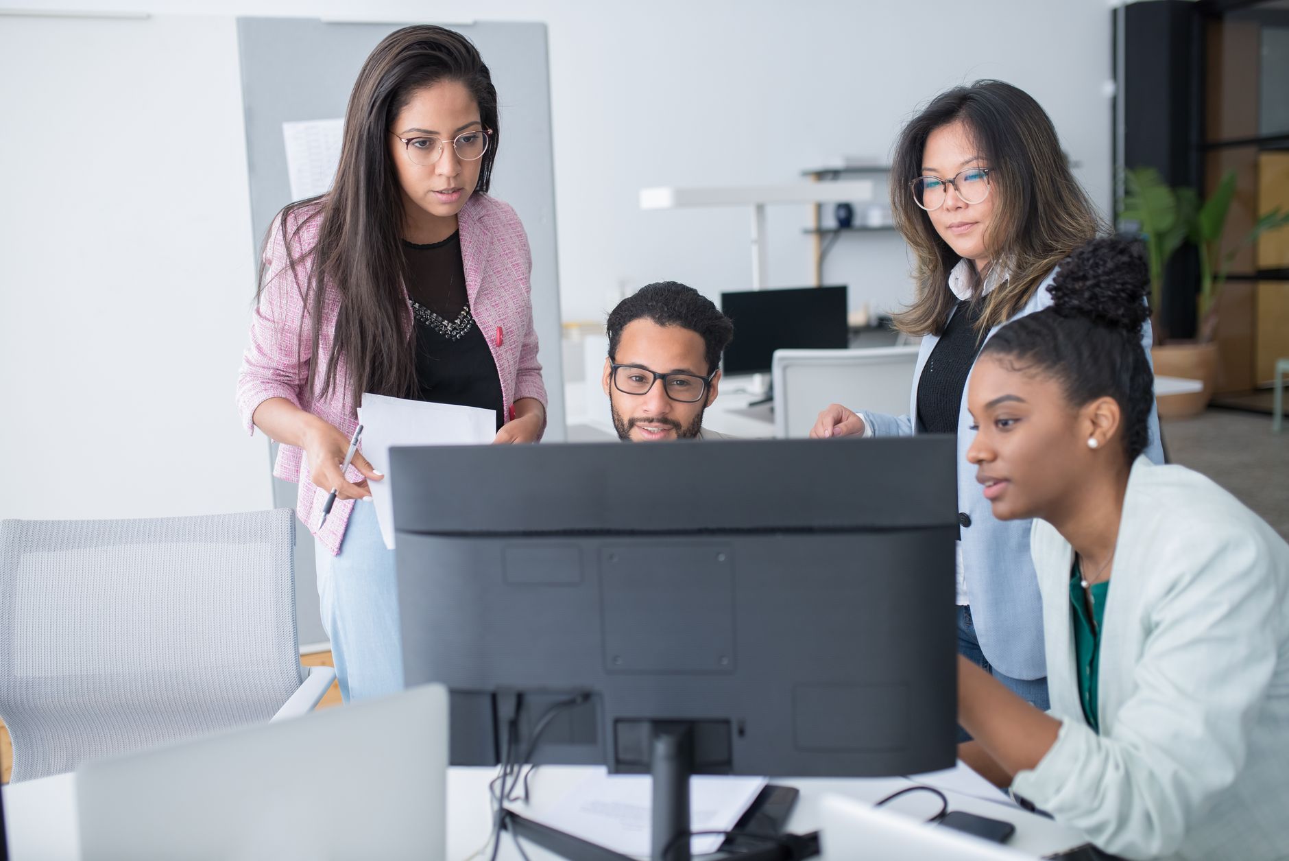 Enterprise team collaborating around screens in a modern office environment