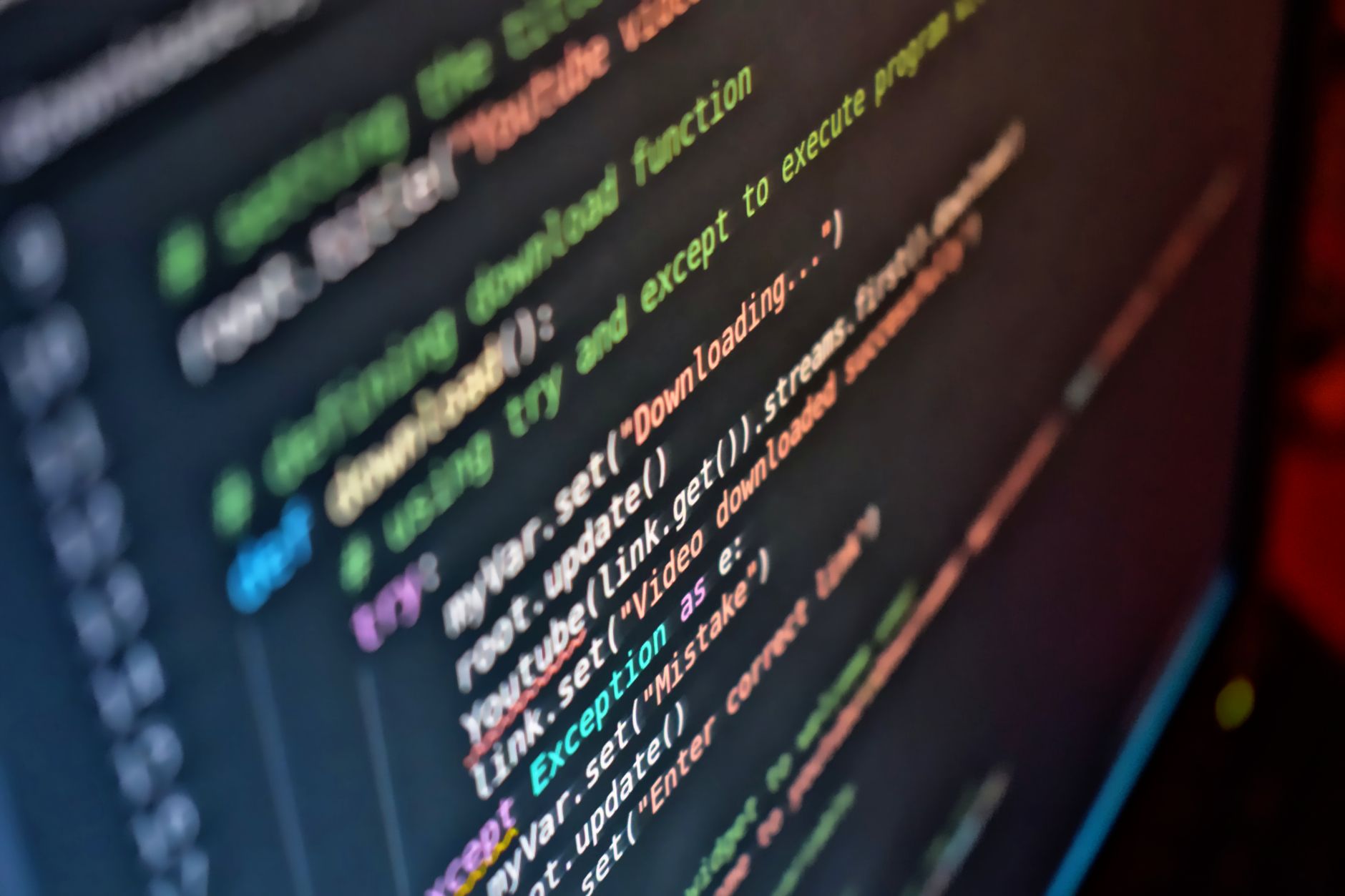 Developer working at a computer screen with code visible in the background