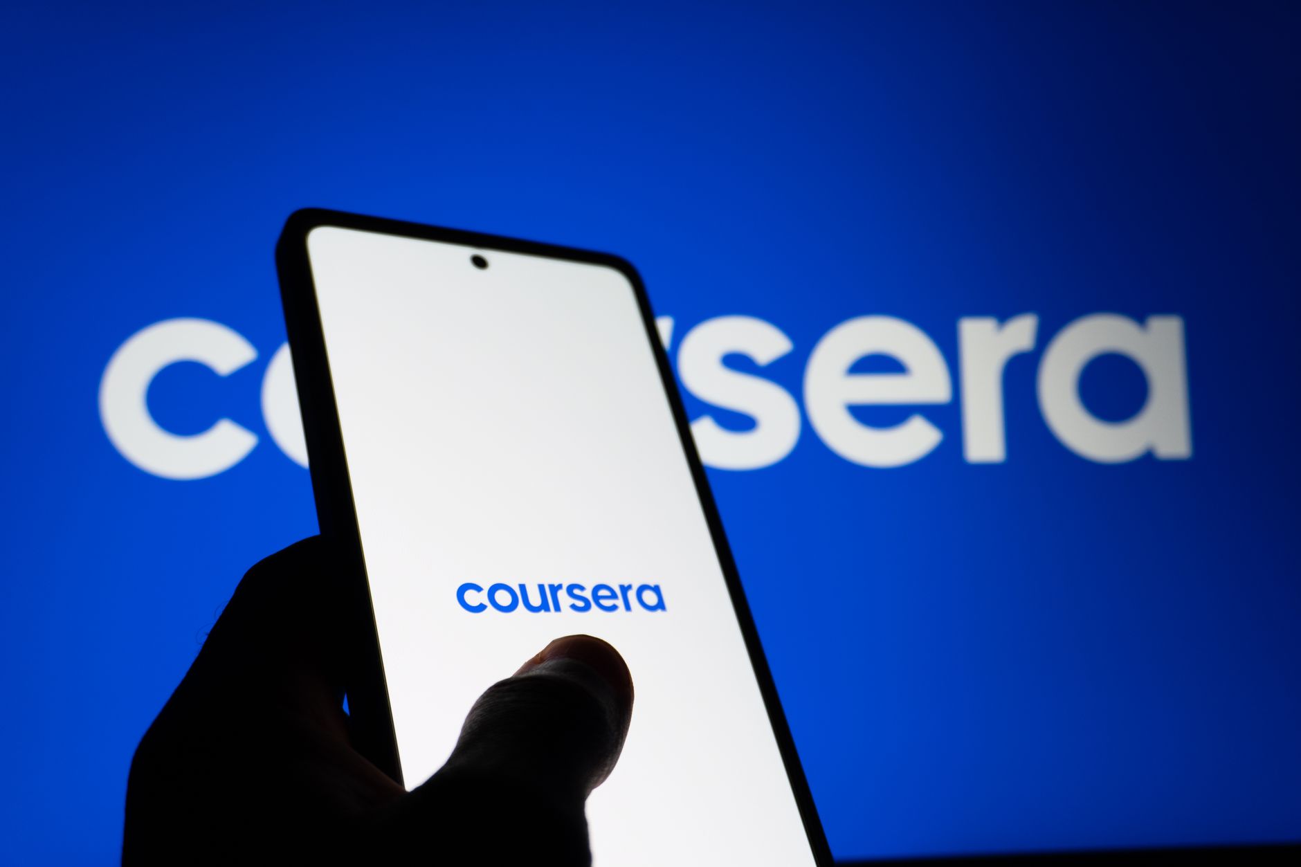 Person using a language learning app on a smartphone at a desk