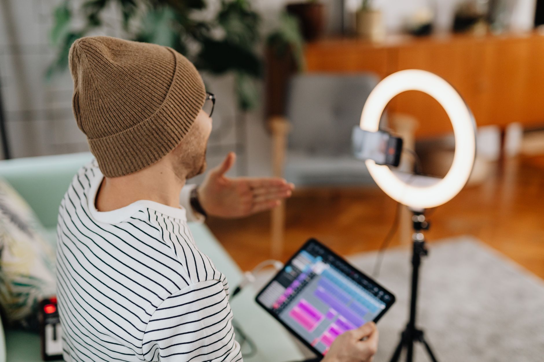 A content creator recording video in a home studio setup with camera and lighting equipment