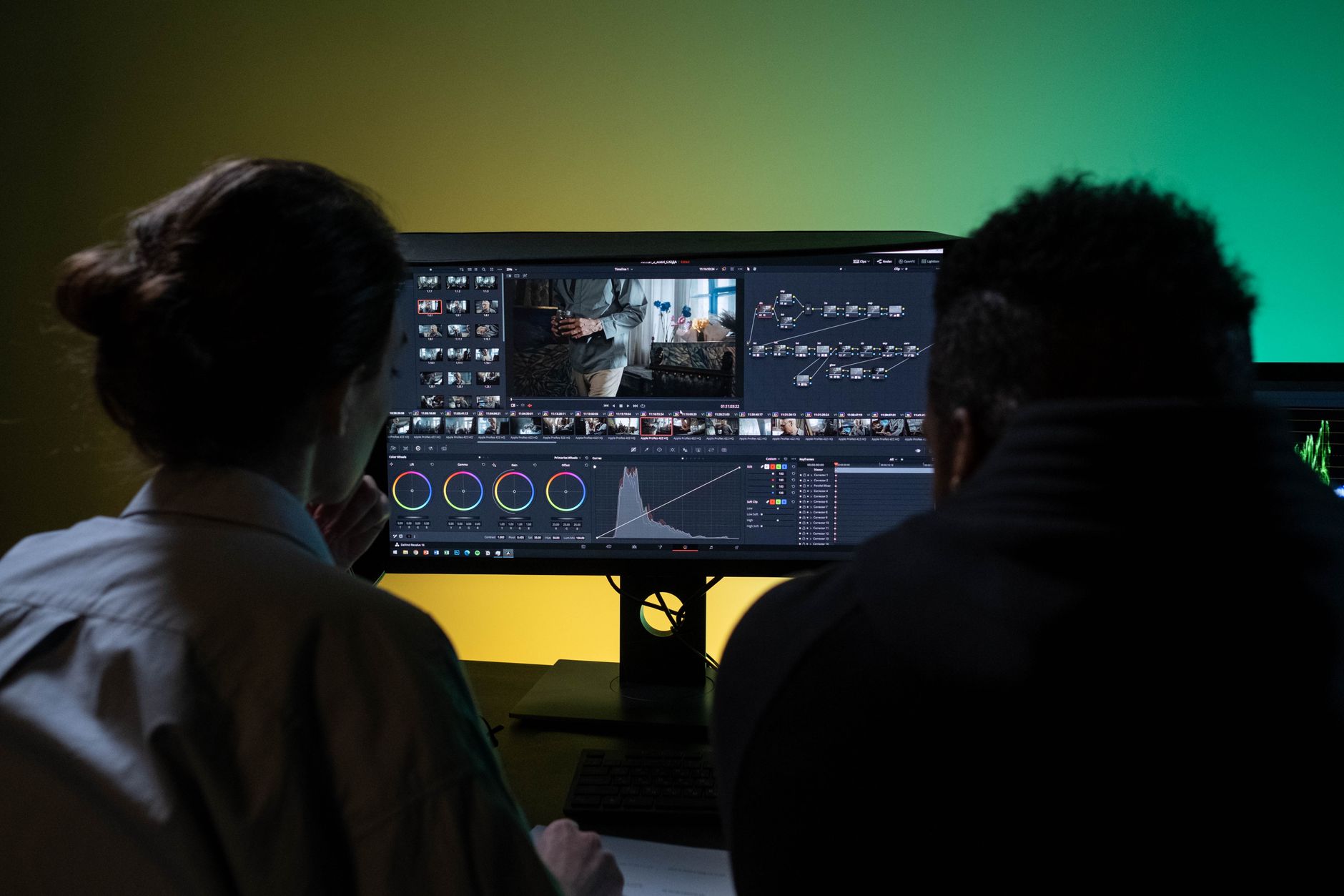 A small creative team reviewing video content on a large monitor in a modern office