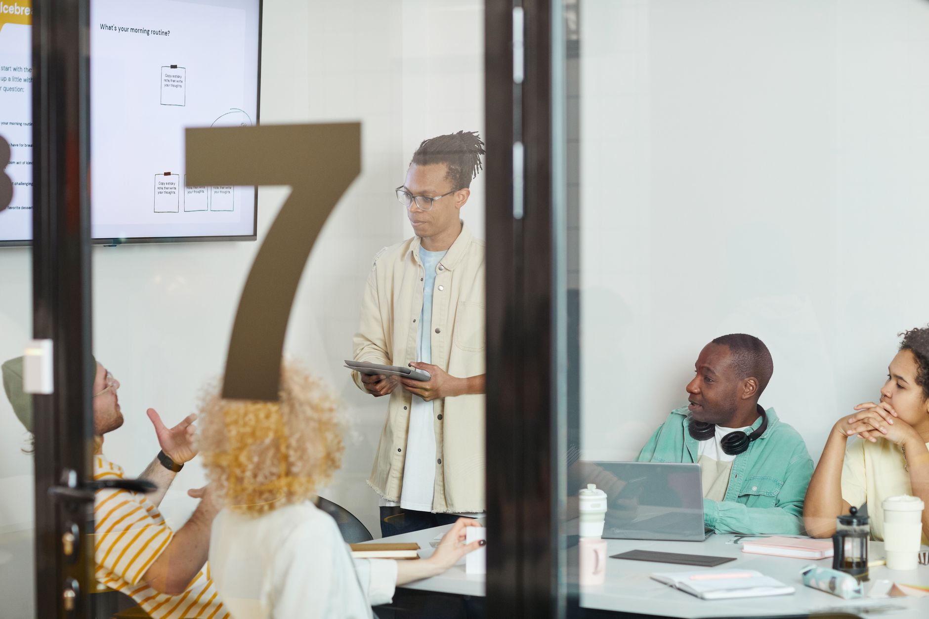Small creative team collaborating around a screen in a modern workspace