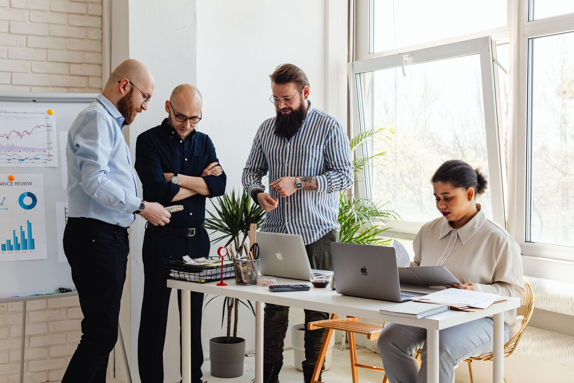 Small team in a meeting reviewing AI workflow tools on a laptop