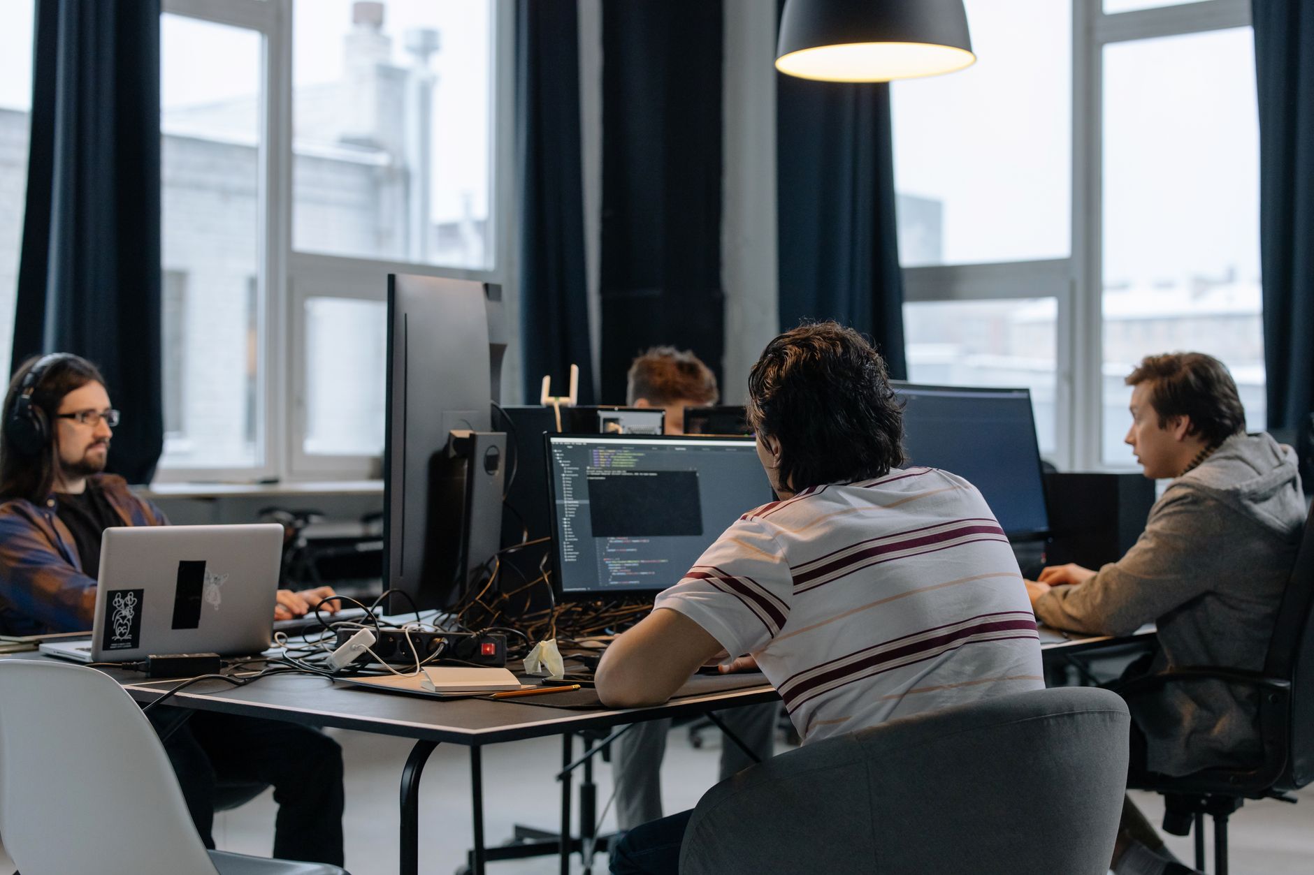 Small startup team collaborating around a table with laptops open