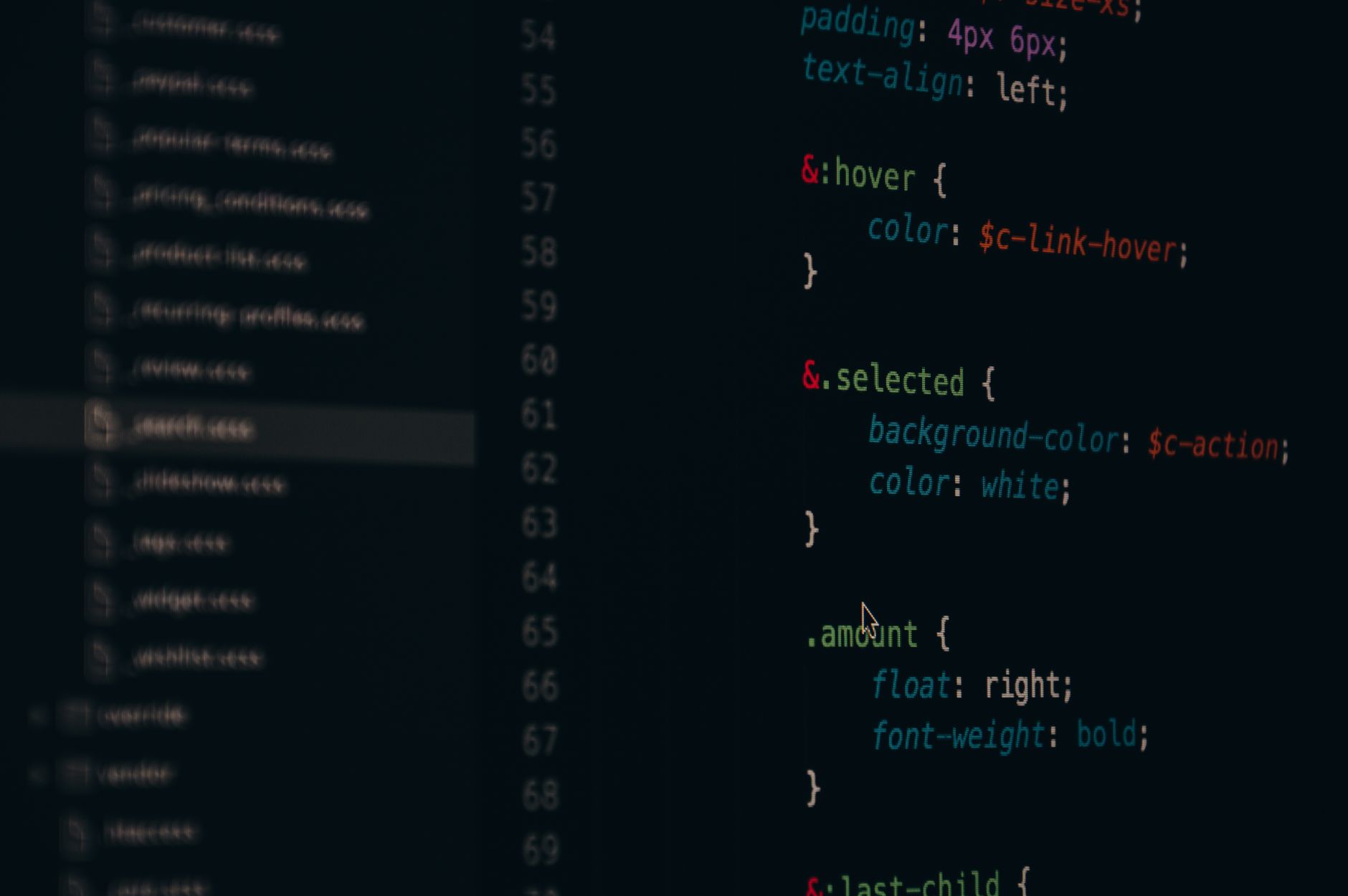A software developer writing code on a computer screen in a modern office environment