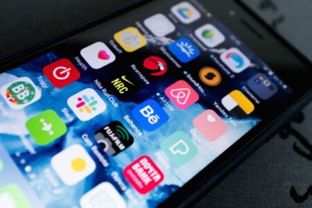 Developer working on a mobile application on a laptop and smartphone