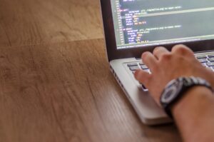 Developer working on a laptop writing frontend code for a web application